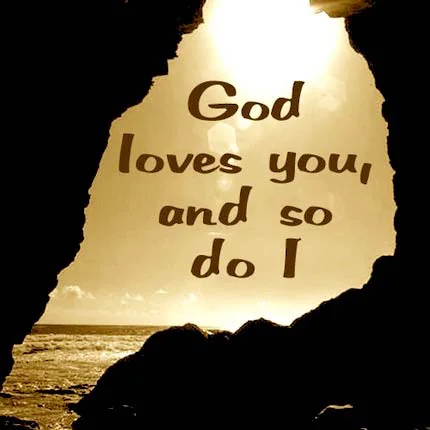 A framed saying reading God loves you, and so do I, backlit by a sunset