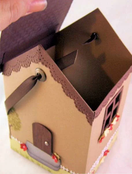 A small handmade paper house gift box with its roof open