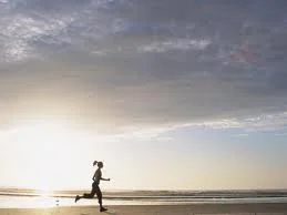 A runner on the beach at sunrise